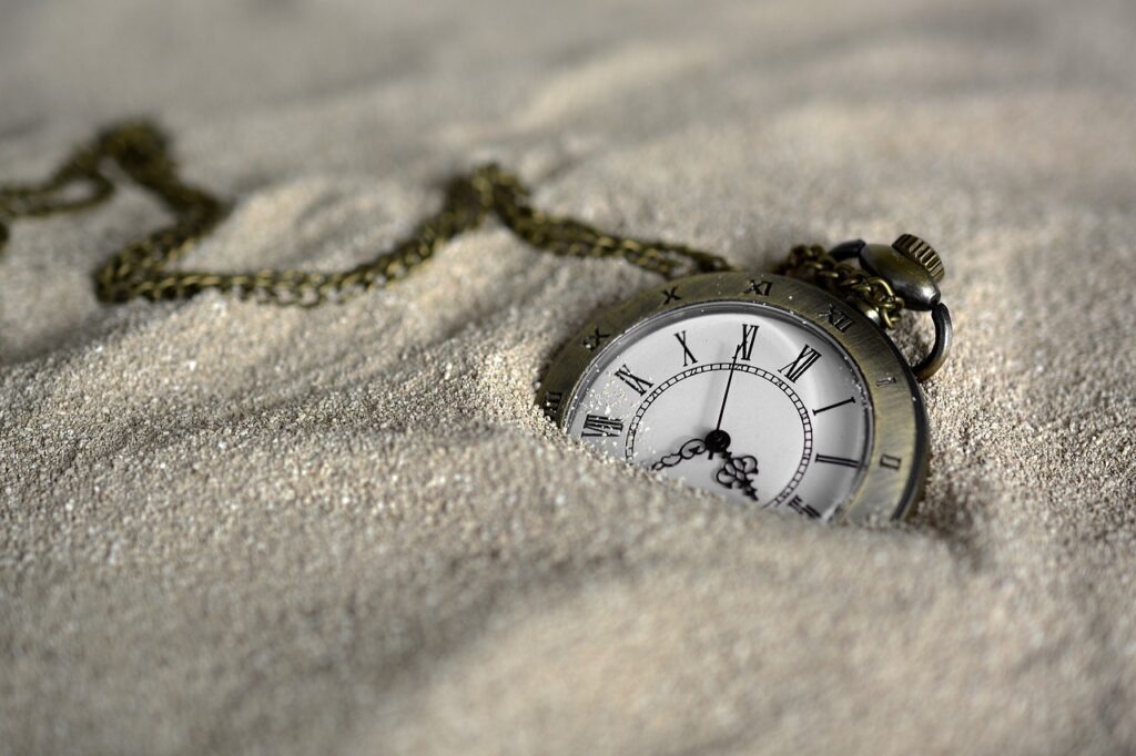 砂に時計が埋もれている